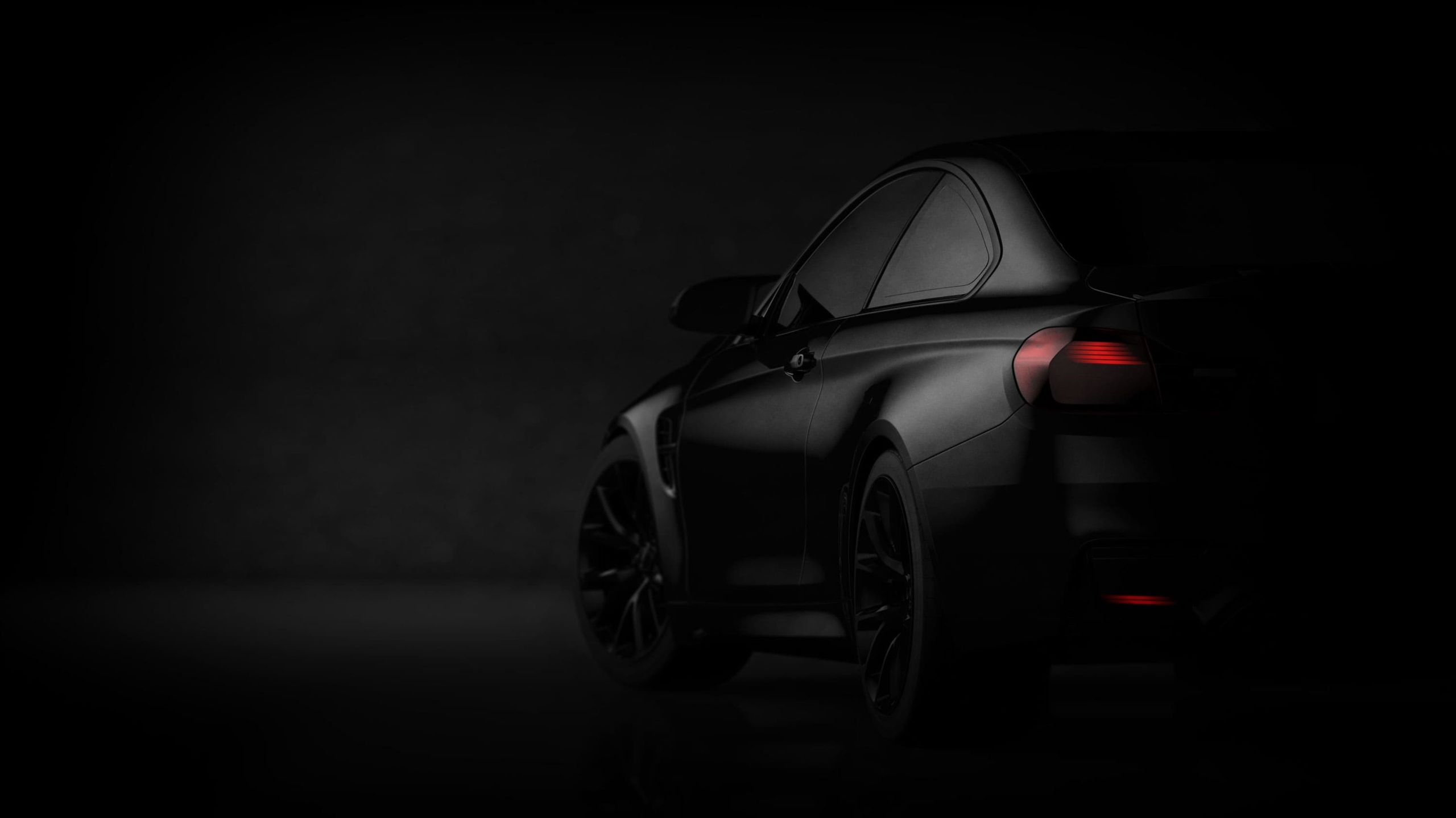 Schwarzer Sportwagen steht im Spotlight vor einem schwarzen Hintergrund